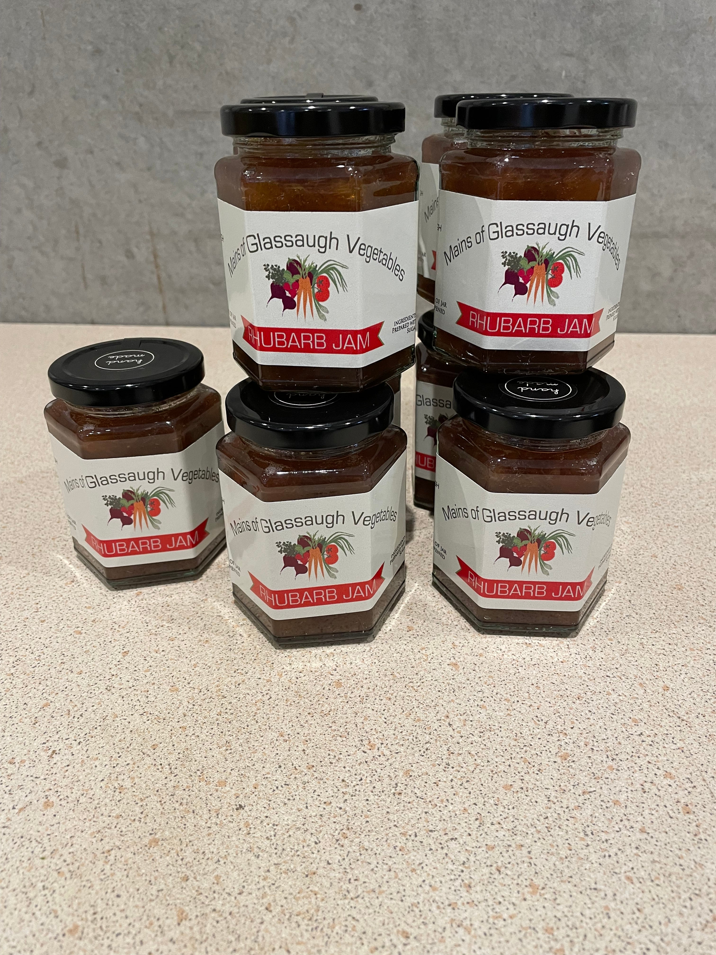 Two jars of grape jelly with visible labels on a reflective surface.